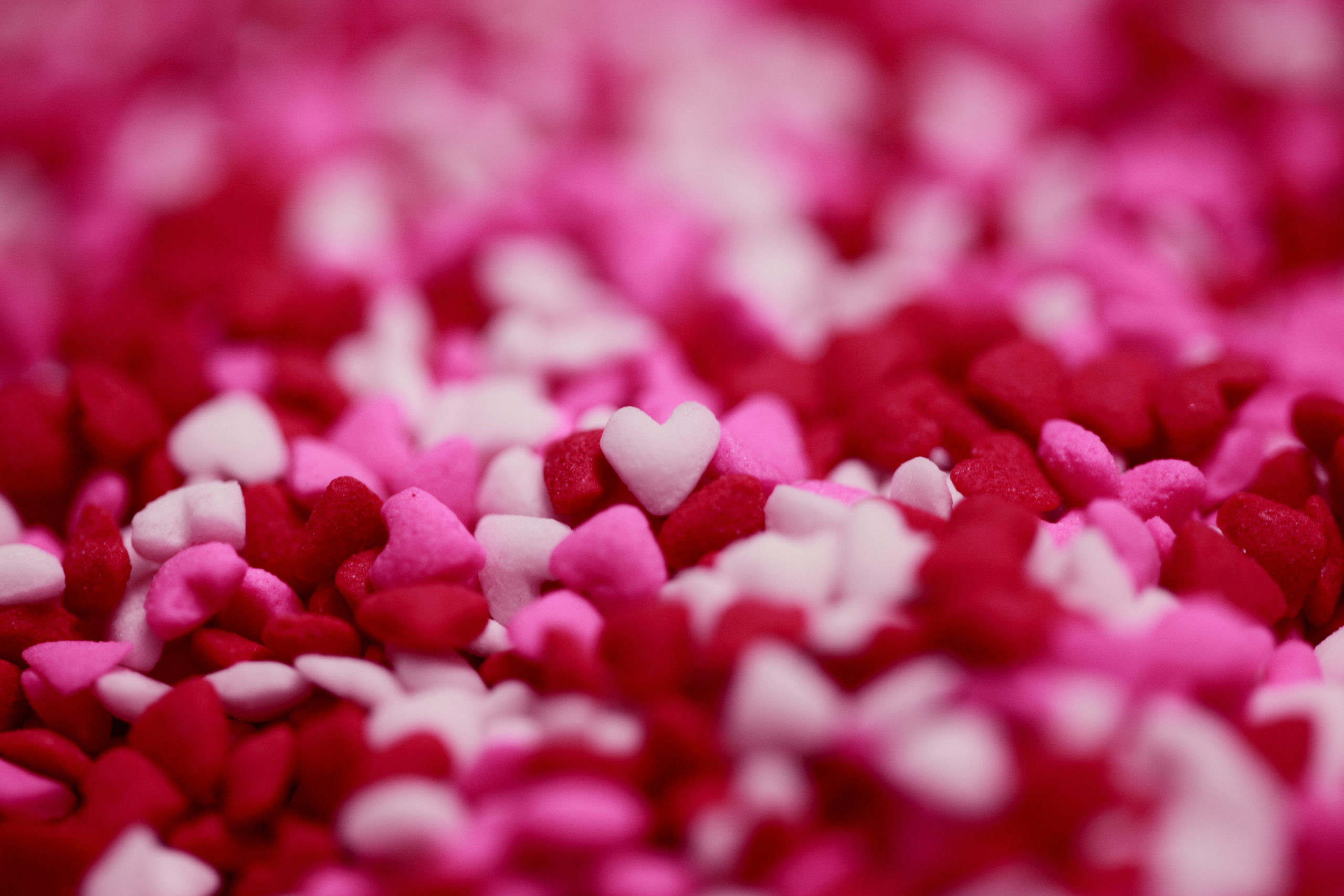 Red, white, and pink candy hearts all jumbled together.