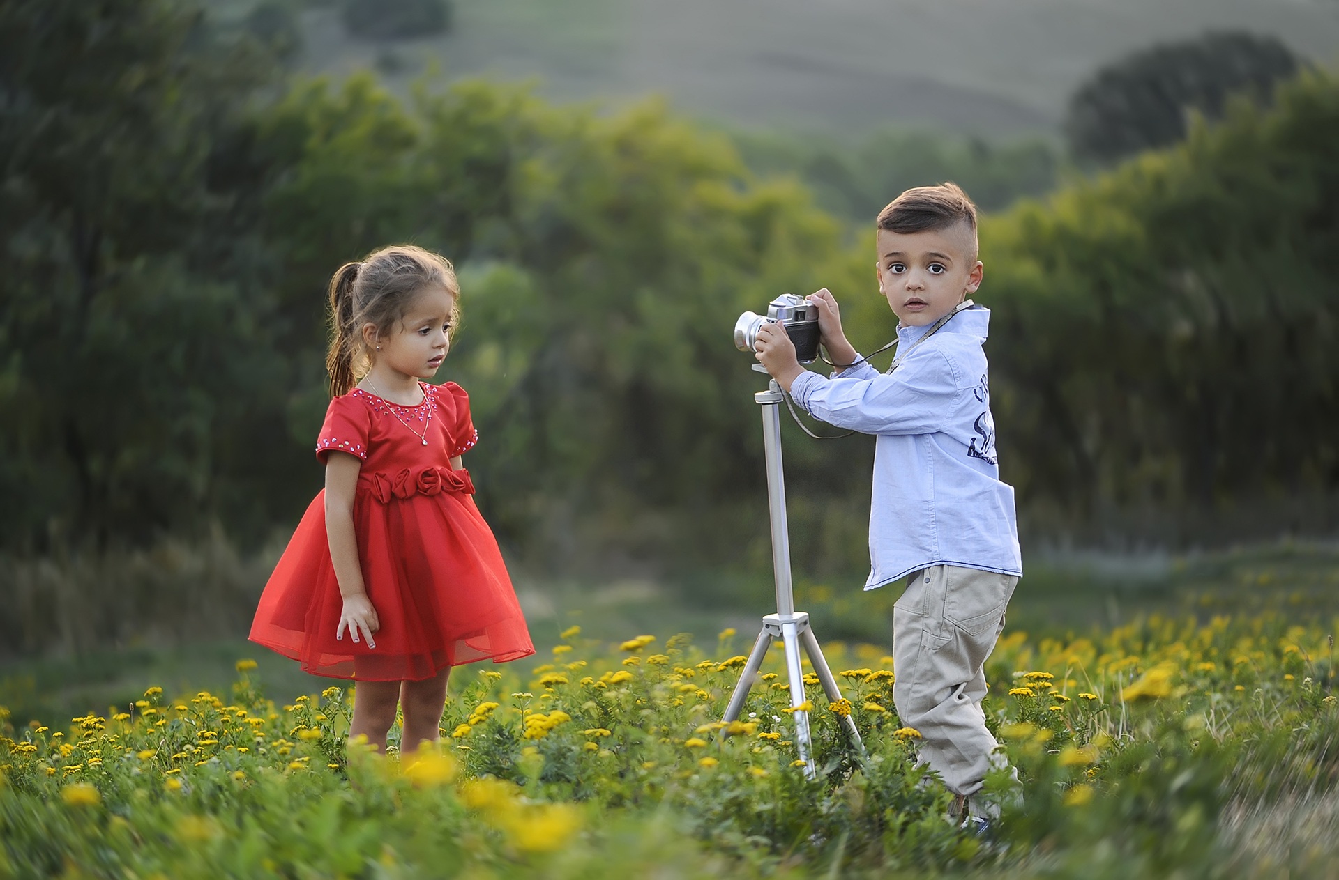 cute children photographers. little boy taking a photo of a little girl.