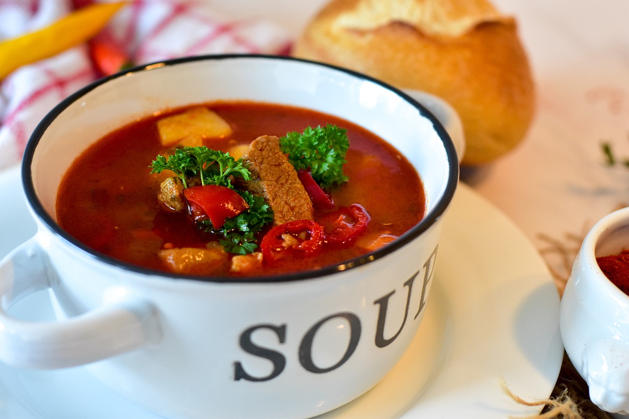 A delicious looking bowl of soup, says so right on the bowl, full of hearty vegetables.