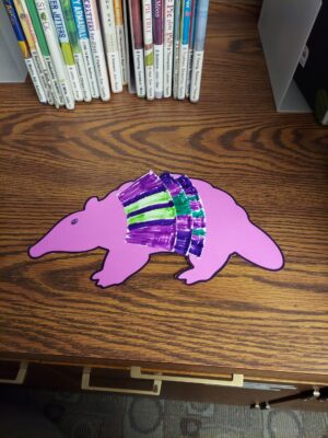 An armadillo made from cardstock and the rim of a paper plate.