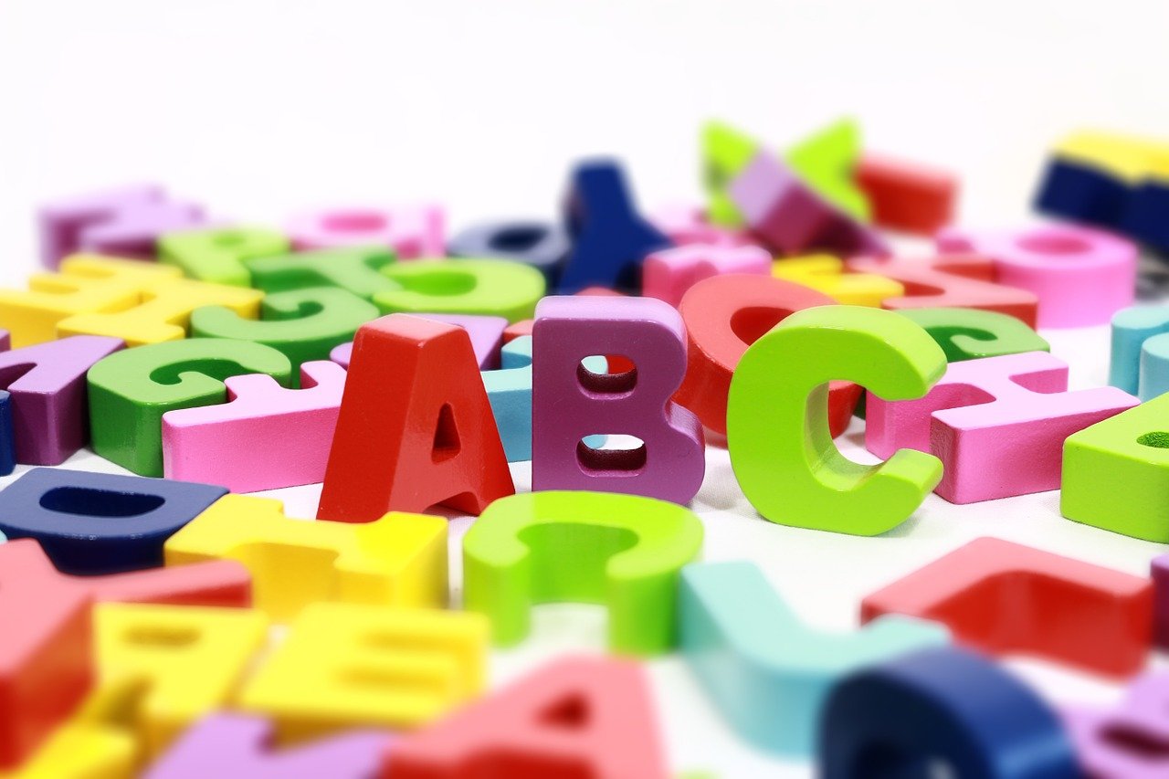 Wooden A B C standing up among the other letters.