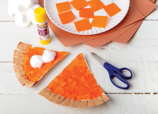 A slice of pumpkin pie made from a paper plate and tissue paper.