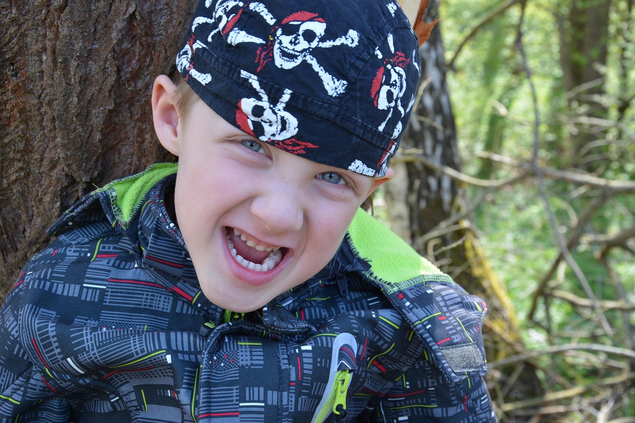 Grinning scallywag wearing a jolly roger covered bandana.