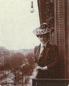 Agatha Christie in a hat on a balcony in France.