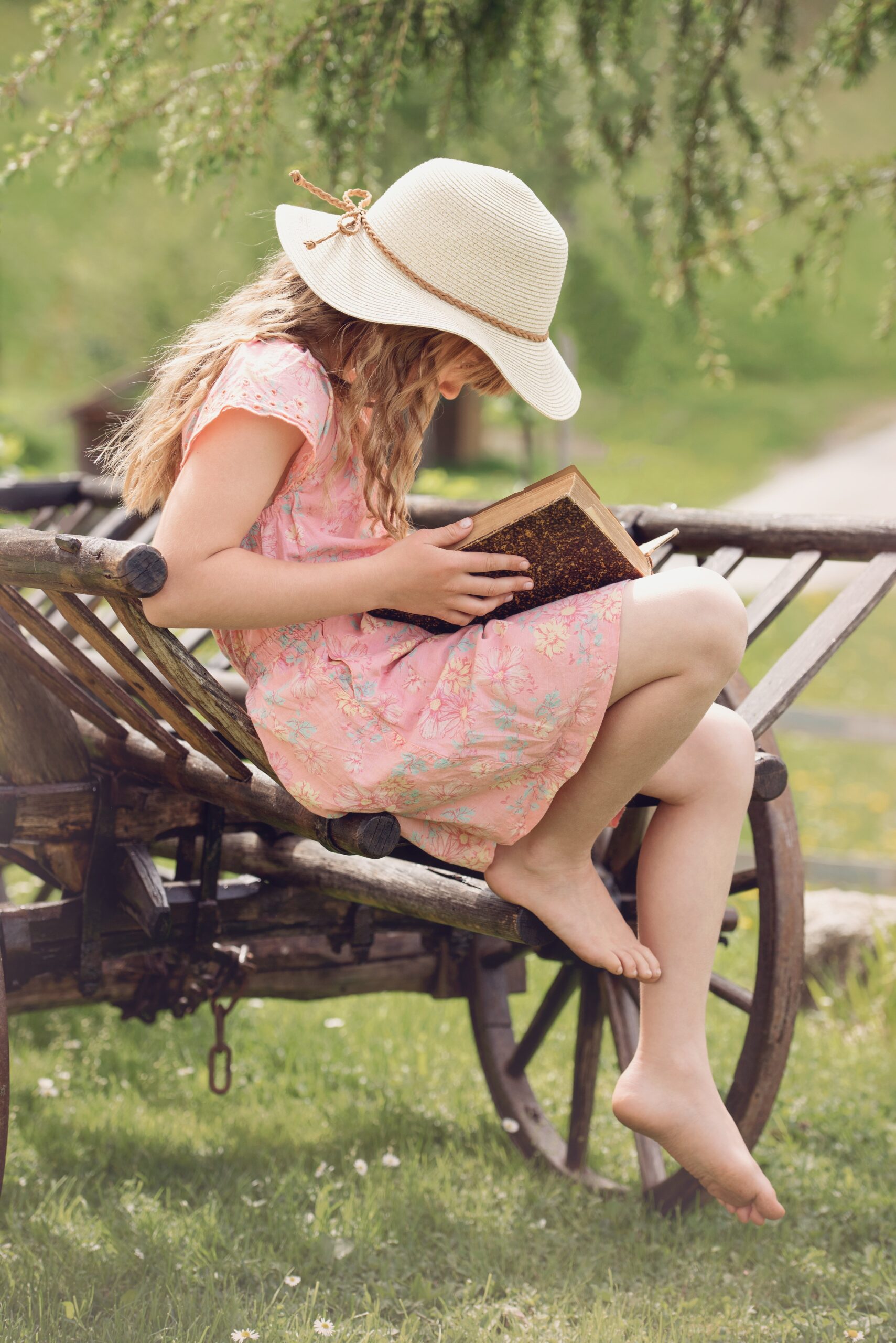 A girl reading a book outside, barefoot and enjoying the good weather.